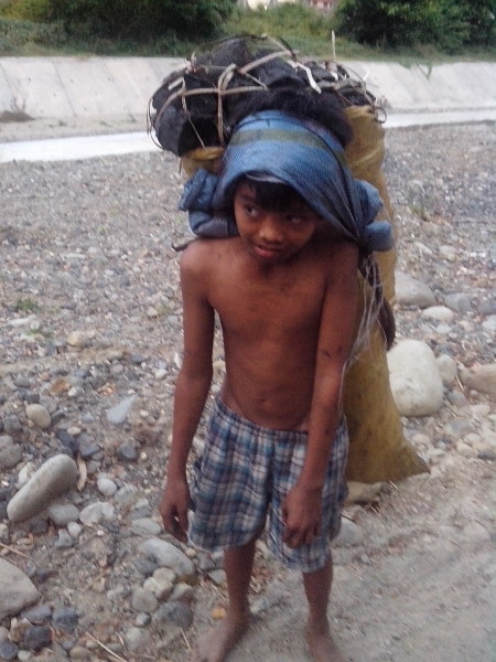kid carrying charcoal in subic