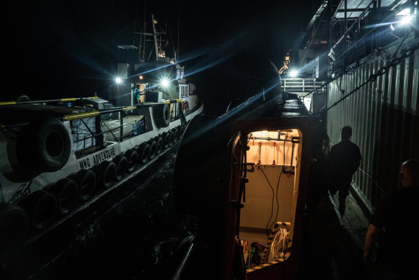 A smaller transport ship disconnected from the Resolution in the dead of night. Credit Ben C. Solomon/The New York Times