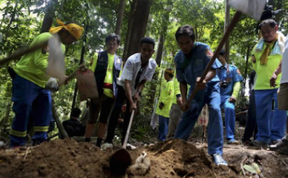 Workers exhume the remains of human trafficking victims from an abandoned mass grave in Thailand. (Reuters file)