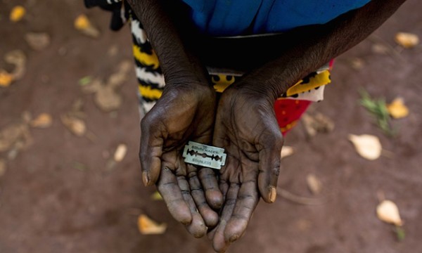 A woman in Mombasa, Kenya, shows the razorblade she uses to cut girls’ genitals. Photograph: Ivan Lieman/Barcroft Media