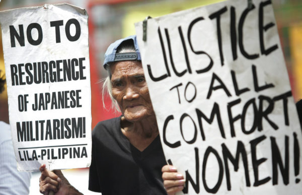 Former Filipino comfort woman Piedad Nobleza, 86, holds slogans during a demonstration outside the Japanese Embassy in suburban Manila on Friday Aug. 15, 2008. Elderly Filipino women and their supporters demanded Tokyo's clear-cut apology and compensation for wartime sexual slavery by Japanese troops. (AP Photo/Aaron Favila)