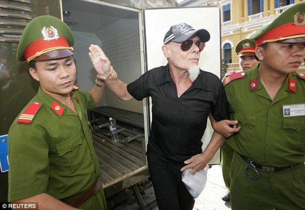 Prisoner: The singer flanked by police guards in Ho Chi Minh City in June 2006