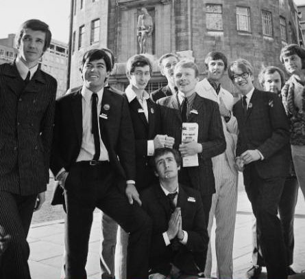 A group of the newly appointed Radio One DJ's pose outside Broadcasting House in 1967. (Left to right) Pete Drummond, Tony Blackburn, Dave Cash, Kenny Everett (kneeling), Duncan Johnson, Chris Denning, Ed Stewart, Mike Ahern, John Peel, unknown CREDIT: ROBERT STIGGINS/EXPRESS/HULTON ARCHIVE/GETTY IMAGES