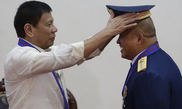  Philippine President Rodrigo Duterte places a hat on the head of police Ronald Dela Rosa during a ceremony in Manila. Photograph: Aaron Favila/AP