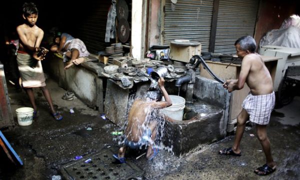  Indian migrant daily wage workers bath at a public well in New Delhi. New information shows that poverty in China and India is worse than previously thought. Photograph: Altaf Qadri/AP