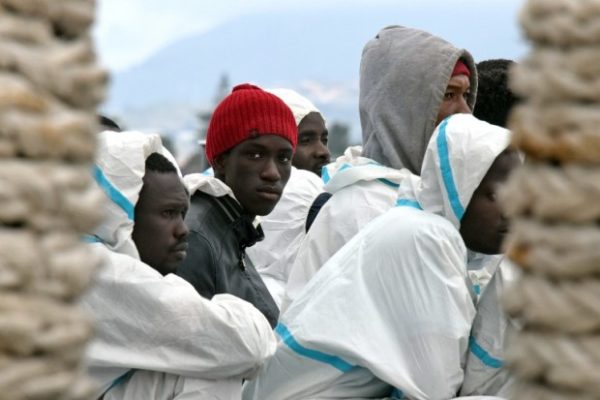 Men wait to disembark from the Italian Coast Guard vessel “Dattilo” following a rescue operation of migrants and refugees at sea, on February 1, 2016, in the port of Messina, Sicily. African migrants trying to reach Europe are being sold into slavery in Libya, including for sex, for as little as $200, international monitors said Tuesday, citing testimony from victims. AFP