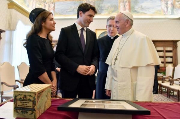 Pope Francis (right) exchanges gifts with Canadian Prime Minister Justin Trudeau (center) and his wife Sophie Gregoire-Trudeau (left) at the end of a private audience at the Vatican on May 29, 2017. AFP