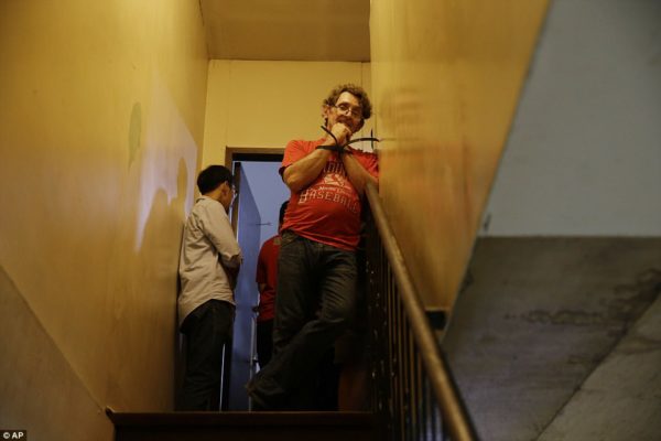  The 53-year-old American is seen smiling at the top of a set of stairs just moments after he was arrested