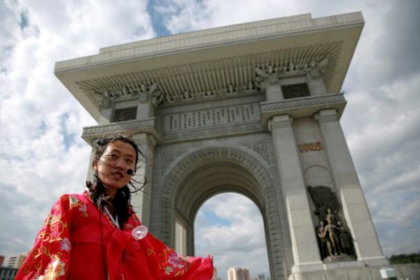 FILE PHOTO: A guide wearing a traditional dress speaks to visitors at the Arch of Triumph in Pyongyang, North Korea May 4, 2016.