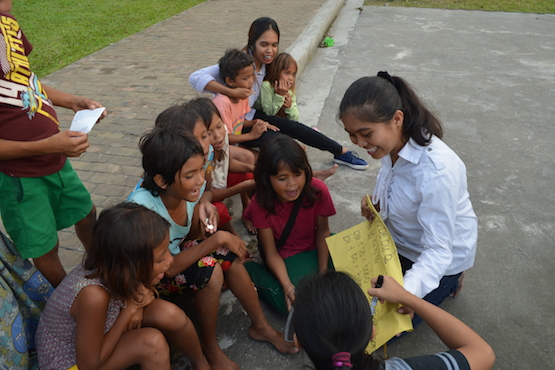 A volunteer teaches young street children to read and write during a weekend activity of the Catholic youth group "Do Life Big" in the southern Philippine city of General Santos. (Photo by Bong Sarmiento)