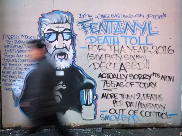 A man walks past a mural by street artist Smokey D. about the fentanyl and opioid overdose crisis in the Downtown Eastside. DARRYL DYCK / THE CANADIAN PRESS