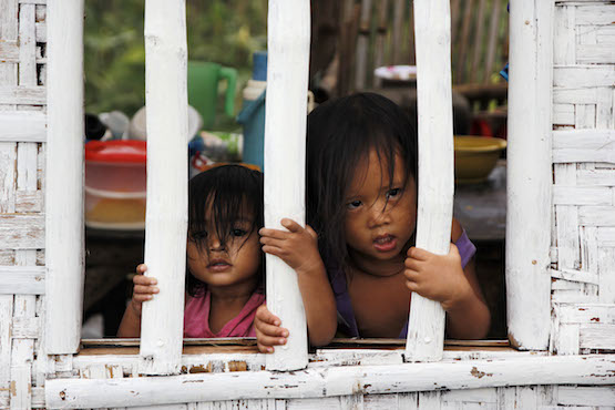 Children watch passersby in a remote village of Cebu. Cases of criminal abuses against women and their children also rose by 200 percent in the Philippines, reports say. (Photo by Joe Torres)