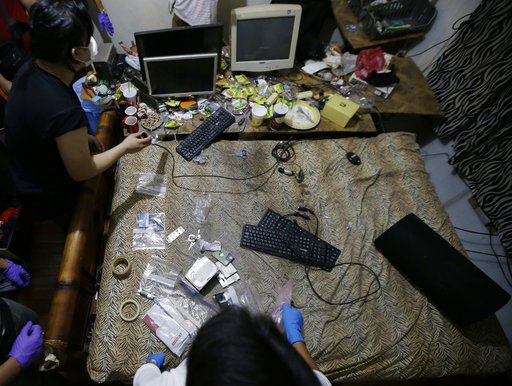 In this April 20, 2017, file photo, members of the National Bureau of Investigation and FBI gather evidence at the home of suspected child webcam cybersex operator, David Timothy Deakin, from Peoria, Ill., during a raid in Mabalacat, Philippines. Authorities in the Philippines on May 5, 2017, arrested three women who were livestreaming sexually exploitative videos of girls to men paying by the minute to watch from half a world away. The incident came just two weeks after Deakin’s arrest where authorities gathered one of the largest seizures of illicit digital content in the country. AP
