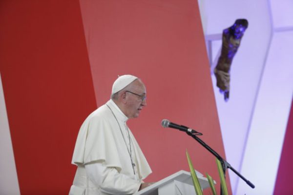 Pope Francis speaks from the podium, below a mutilated statue of Christ, during a prayer meeting for reconciliation at Las Malocas Park in Villavicencio, Colombia, Friday, Sept. 8, 2017. The event brings victims and victimizers together before the poignant symbol of the conflict: a mutilated statue of Christ rescued from a church destroyed in a rebel mortar attack 15 years ago. (AP Photo/Andrew Medichini)