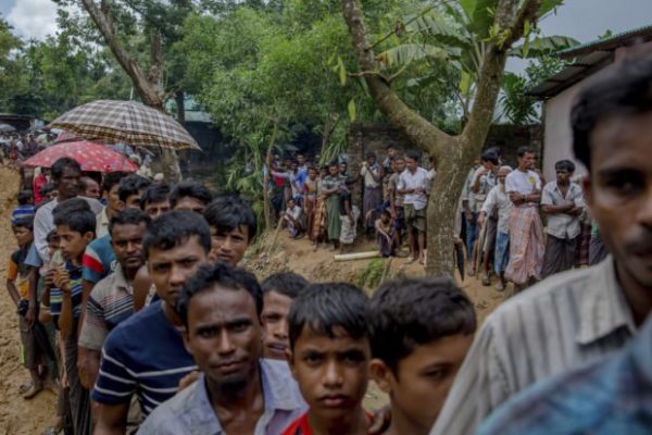 Newly arrived Rohingya wait for their turn to collect building material for their shelters distributed by aid agencies in Kutupalong refugee camp, Bangladesh, Wednesday, Sept. 13, 2017. With Rohingya refugees still flooding across the border from Myanmar, those packed into camps and makeshift settlements in Bangladesh were becoming desperate for scant basic resources as hunger and illness soared. (AP Photo/Dar Yasin)