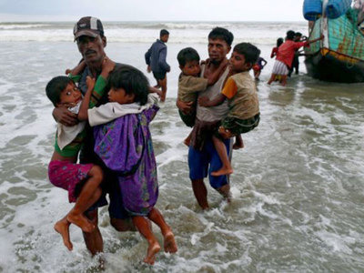 Rohingya refugee children carried to the shore after crossing the Bangladesh-Myanmar border by boat in Teknaf (Reuters File Photo)
