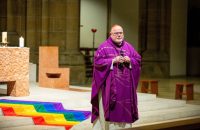 German Cardinal Reinhard Marx of Munich and Freising speaks in front of a rainbow flag during a service marking the 20th anniversary of the LGBTQ community at St. Paul's Church in Munich March 13, 2022. (CNS photo/Lukas Barth, Reuters)